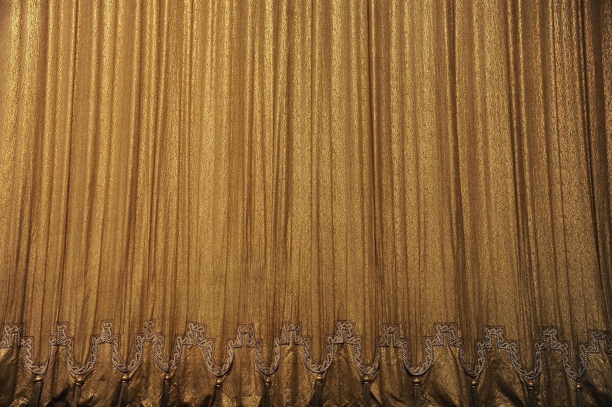 A red theater curtain, slightly parted