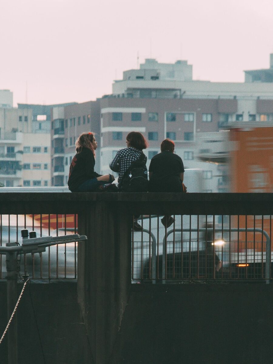 Friends sitting together on a rooftop overlooking a city