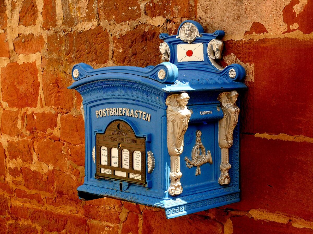 A bright red mailbox against a wall