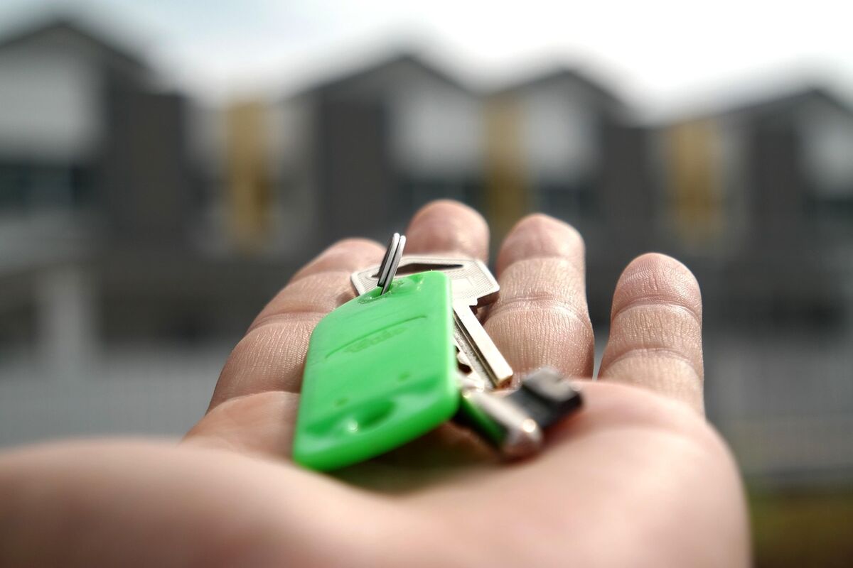 A hand holding out house keys